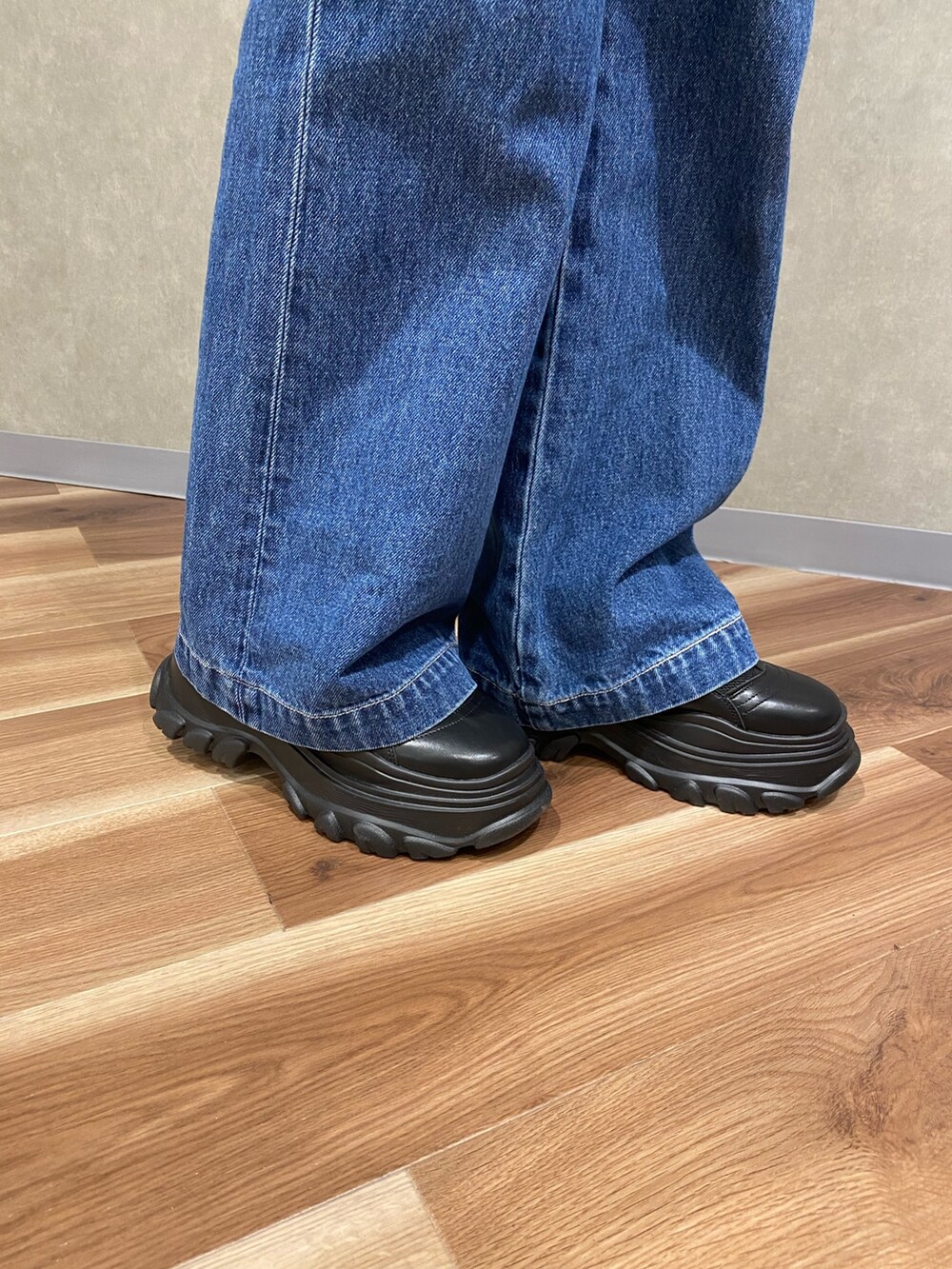 ブラック系のスニーカー、ブルー系のシャツ/ブラウス、ホワイト系のTシャツ/カットソーを着用したレディースの春コーディネートの6枚目の写真
