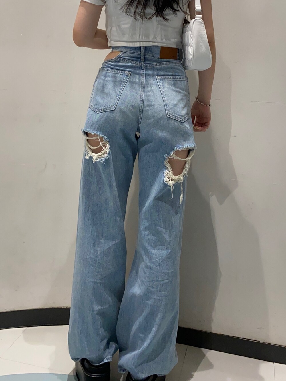 ホワイト系のTシャツ/カットソー、ブルー系のデニムパンツ、ブラック系のサンダルを着用したレディースの夏コーディネートの4枚目の写真