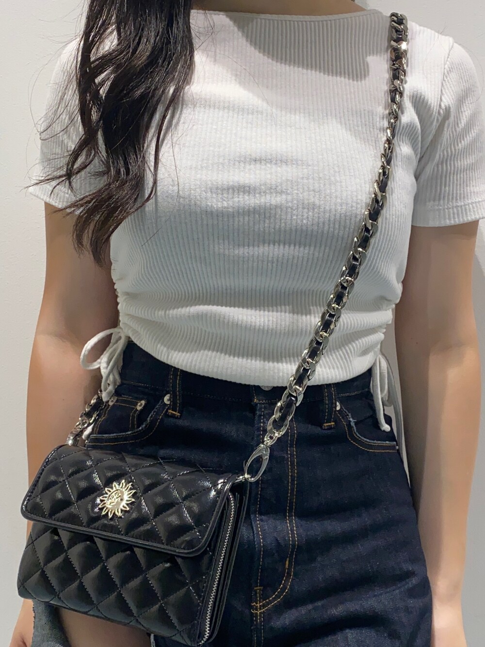 ホワイト系のTシャツ/カットソー、ブラック系のショルダーバッグ、ブルー系のデニムパンツを着用したレディースの夏コーディネートの6枚目の写真