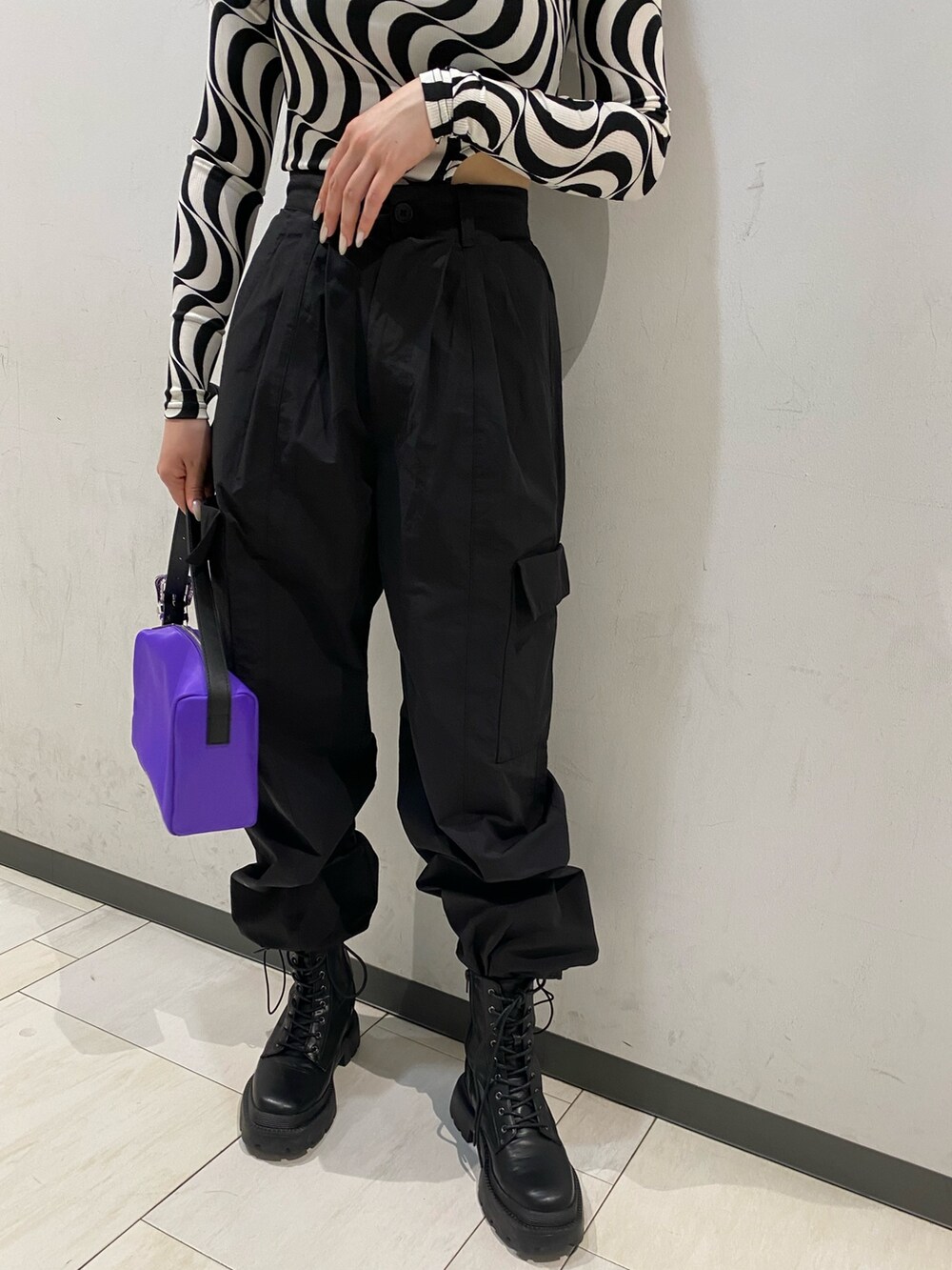 ブラック系のTシャツ/カットソー、パープル系のハンドバッグ、ブラック系のブーツを着用したレディースの春コーディネートの5枚目の写真