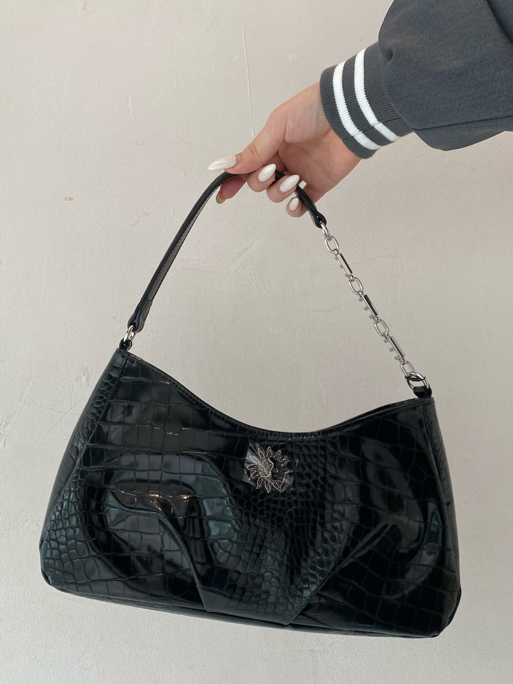 グレー系のテーラードジャケット、ブルー系のデニムパンツ、ブラック系のブーツを着用したレディースの秋コーディネートの6枚目の写真