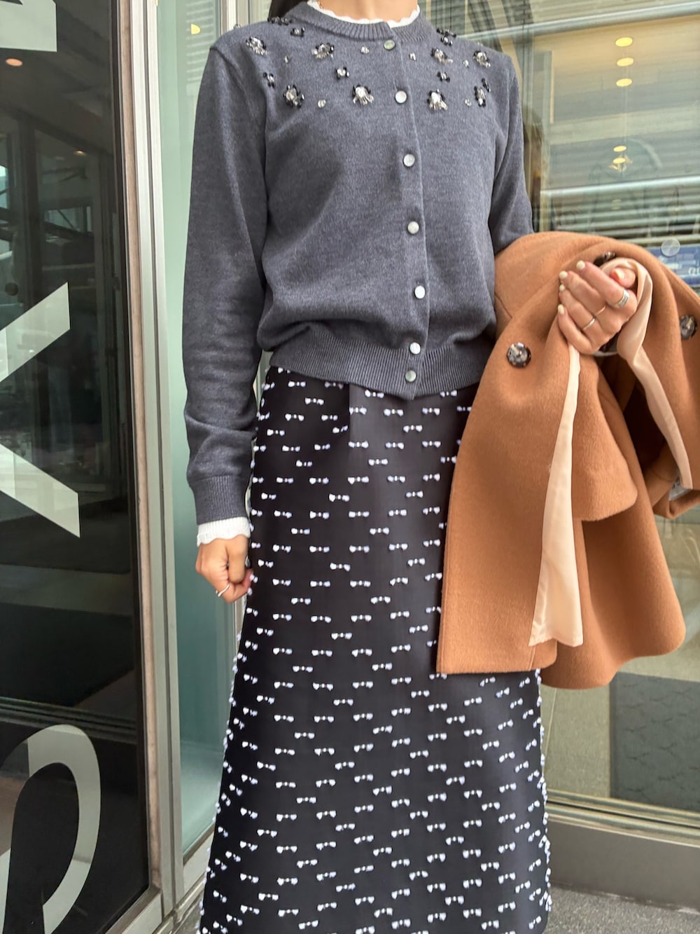 ブラック系のスカート、グレー系のカーディガン/ボレロを着用したレディースの冬コーディネートの2枚目の写真