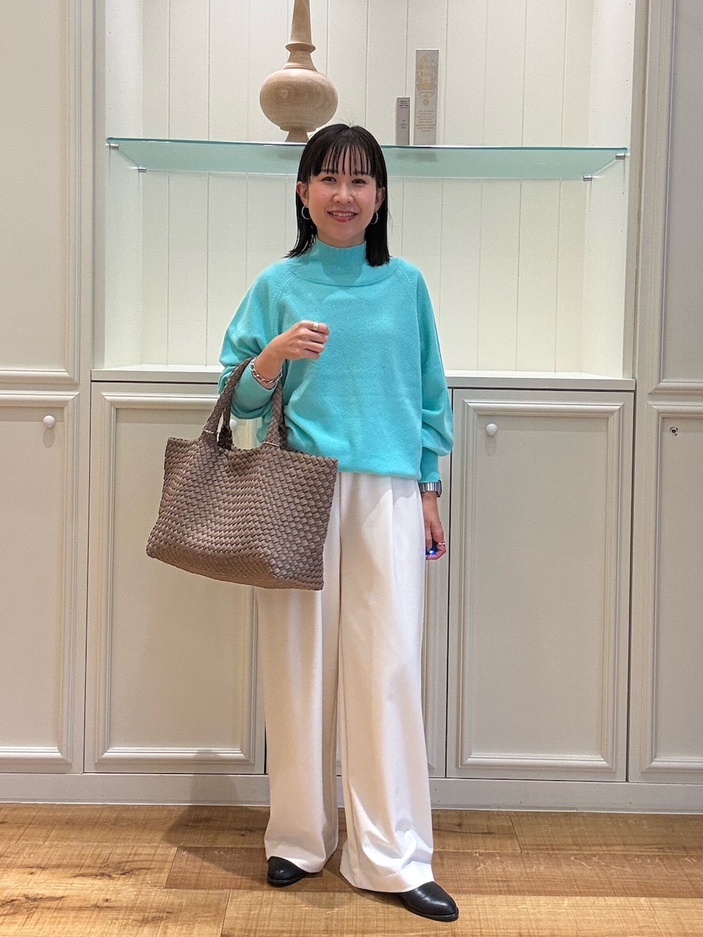 グリーン系のニット/セーター、ベージュ系のトートバッグ、ホワイト系のその他パンツを着用したレディースの秋コーディネートの5枚目の写真