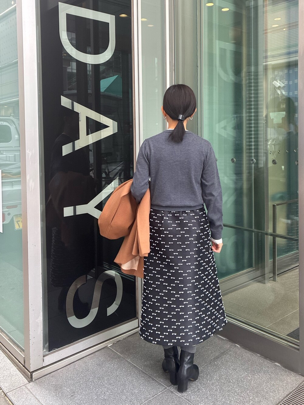 ブラック系のスカート、グレー系のカーディガン/ボレロを着用したレディースの冬コーディネートの4枚目の写真