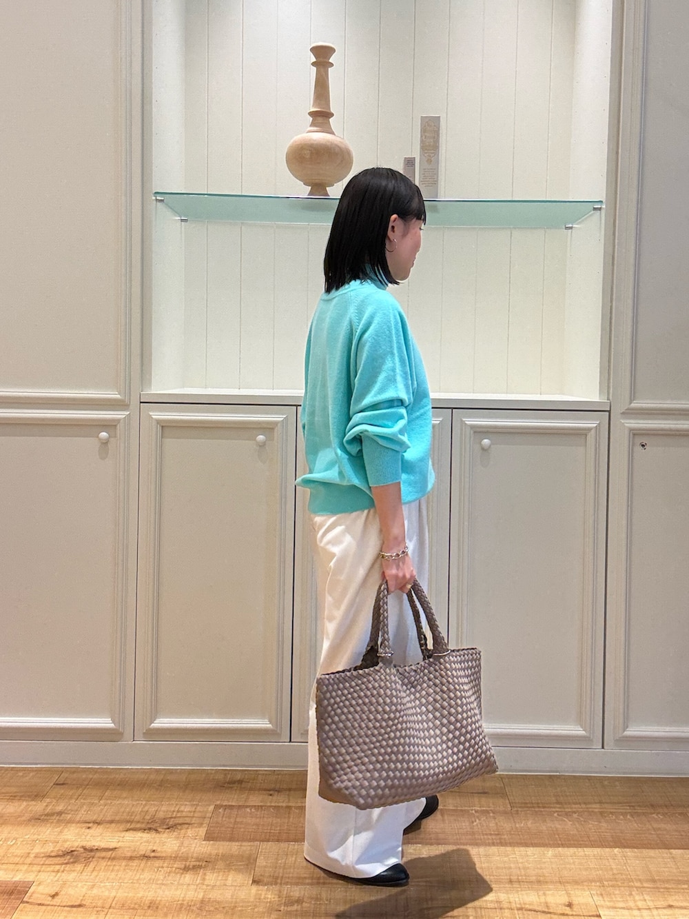 グリーン系のニット/セーター、ベージュ系のトートバッグ、ホワイト系のその他パンツを着用したレディースの秋コーディネートの2枚目の写真