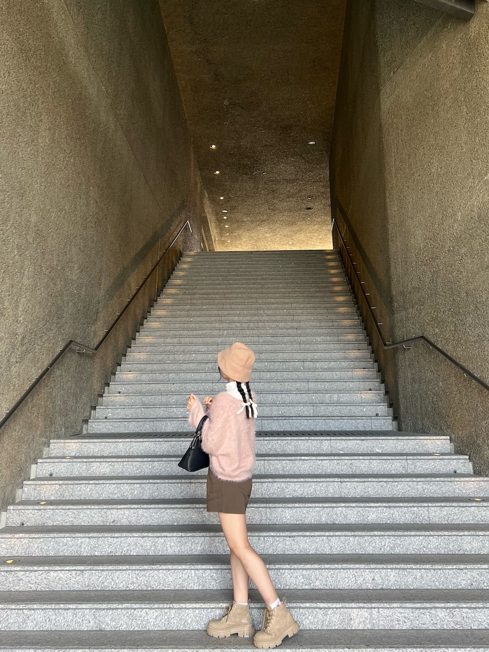 ピンク系のニット/セーター、ブラウン系のその他パンツ、ベージュ系のシューズを着用したレディースの春コーディネートの3枚目の写真