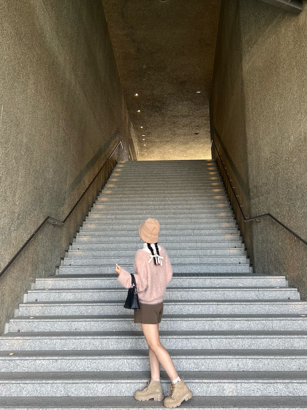 ピンク系のニット/セーター、ブラウン系のその他パンツ、ベージュ系のシューズを着用したレディースの春コーディネートの4枚目の写真