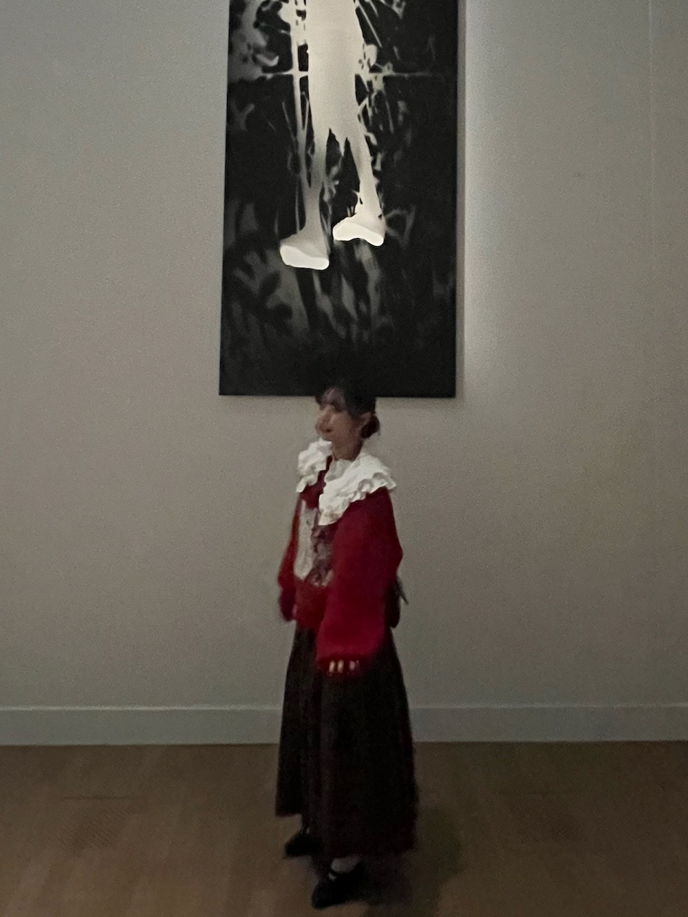 レッド系のニット/セーター、ホワイト系のシャツ/ブラウス、グリーン系のスカートを着用したレディースの春コーディネートの2枚目の写真