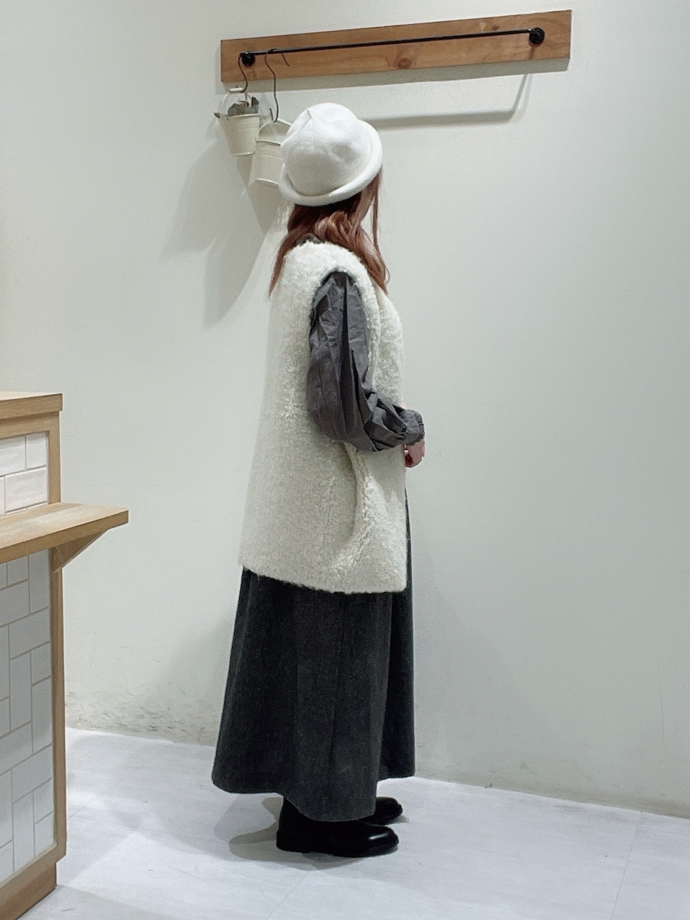 ブラック系のスカート、ブラック系のブーツ、ブラウン系のシャツ/ブラウスを着用したレディースの秋コーディネートの3枚目の写真