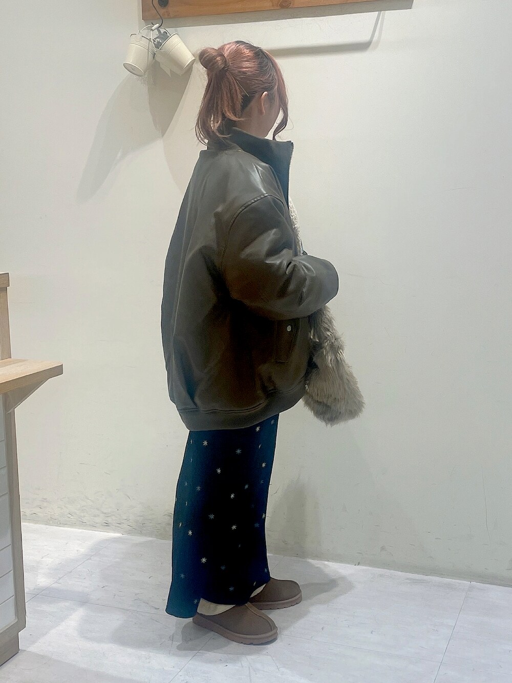 ブラウン系のジャケット/アウター、グレー系のTシャツ/カットソー、ブラック系のスカートを着用したレディースの冬コーディネートの3枚目の写真