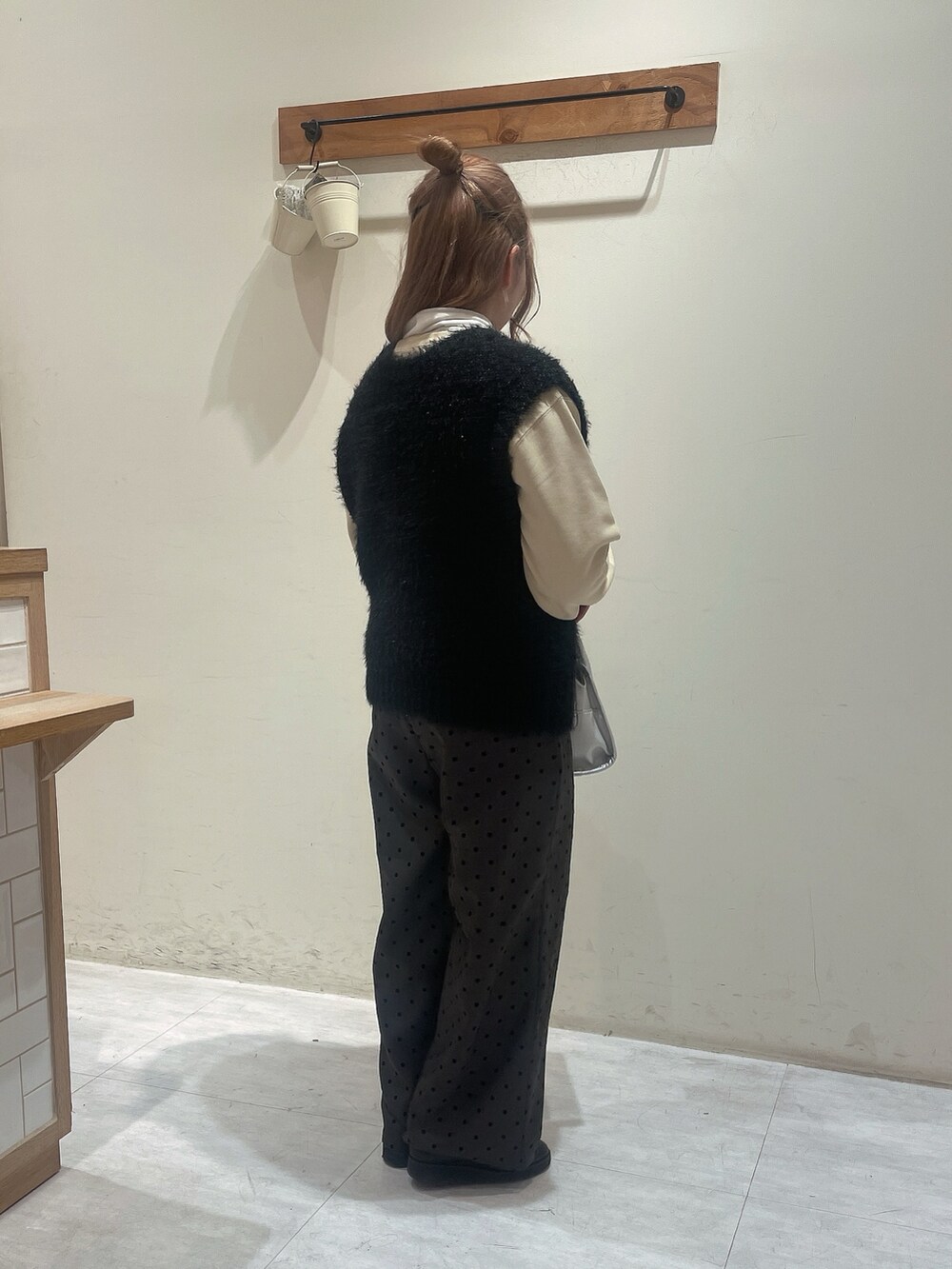 イエロー系のTシャツ/カットソー、ホワイト系のTシャツ/カットソー、ブラック系のニット/セーターを着用したレディースの冬コーディネートの2枚目の写真