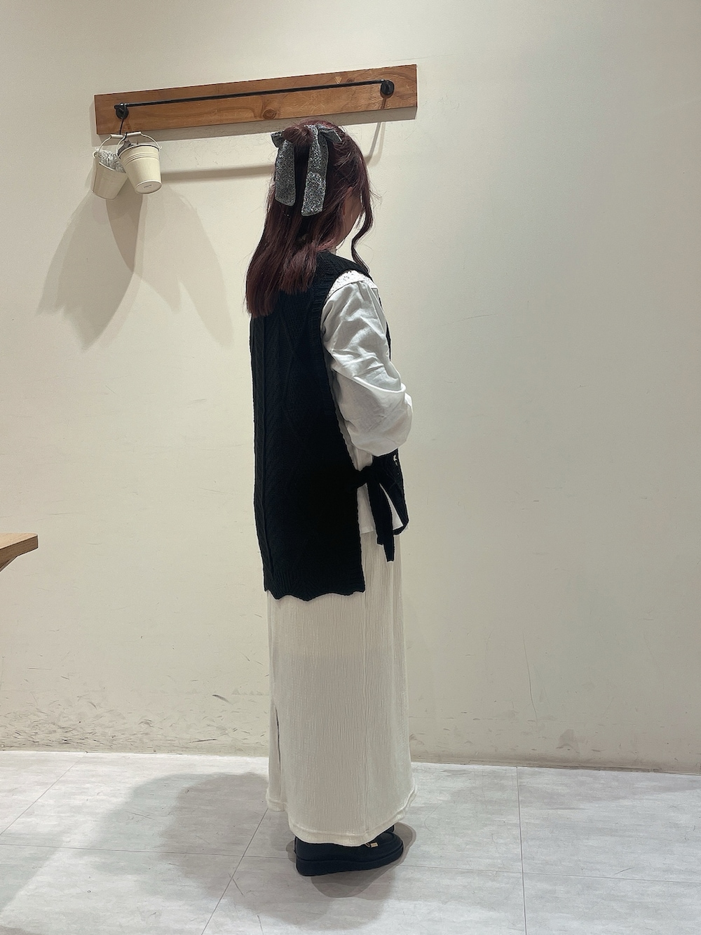 ブラック系のベスト、ホワイト系のシャツ/ブラウス、ホワイト系のスカートを着用したレディースの冬コーディネートの2枚目の写真