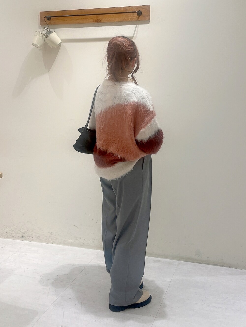 ブラウン系のニット/セーター、オレンジ系のシャツ/ブラウス、グレー系のその他パンツを着用したレディースの冬コーディネートの2枚目の写真