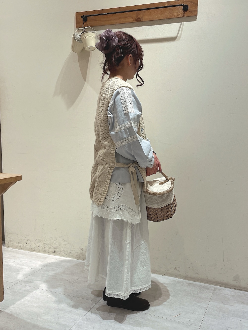 ホワイト系のベスト、ブルー系のシャツ/ブラウス、ホワイト系のスカートを着用したレディースの冬コーディネートの2枚目の写真