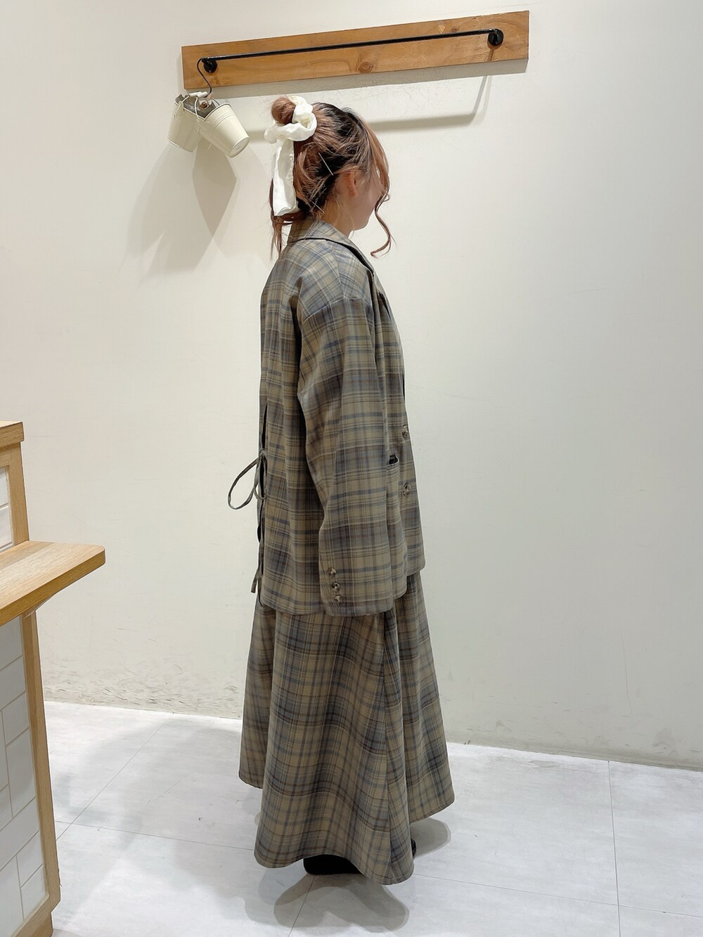 ブラウン系のノーカラージャケット、ホワイト系のTシャツ/カットソー、ブラウン系のワンピースを着用したレディースの春コーディネートの2枚目の写真