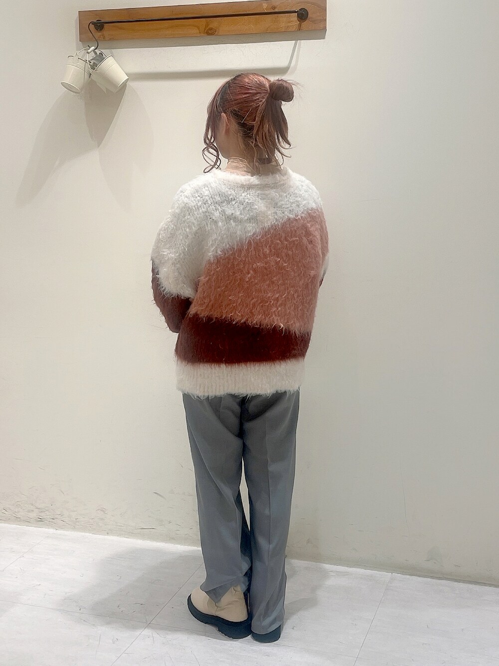 ブラウン系のニット/セーター、オレンジ系のシャツ/ブラウス、グレー系のその他パンツを着用したレディースの冬コーディネートの3枚目の写真