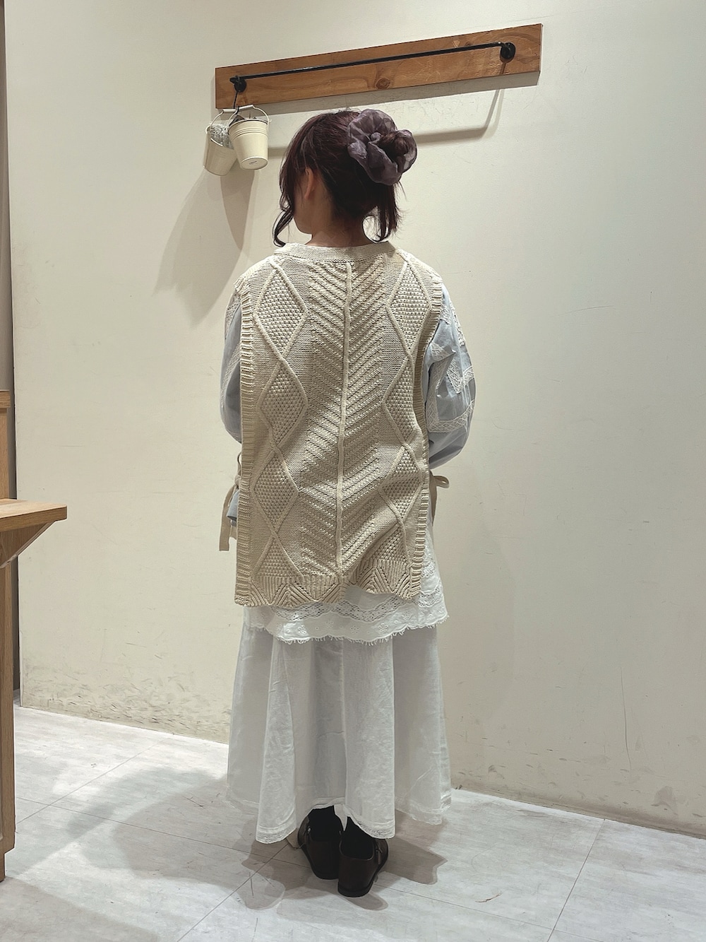 ホワイト系のベスト、ブルー系のシャツ/ブラウス、ホワイト系のスカートを着用したレディースの冬コーディネートの3枚目の写真