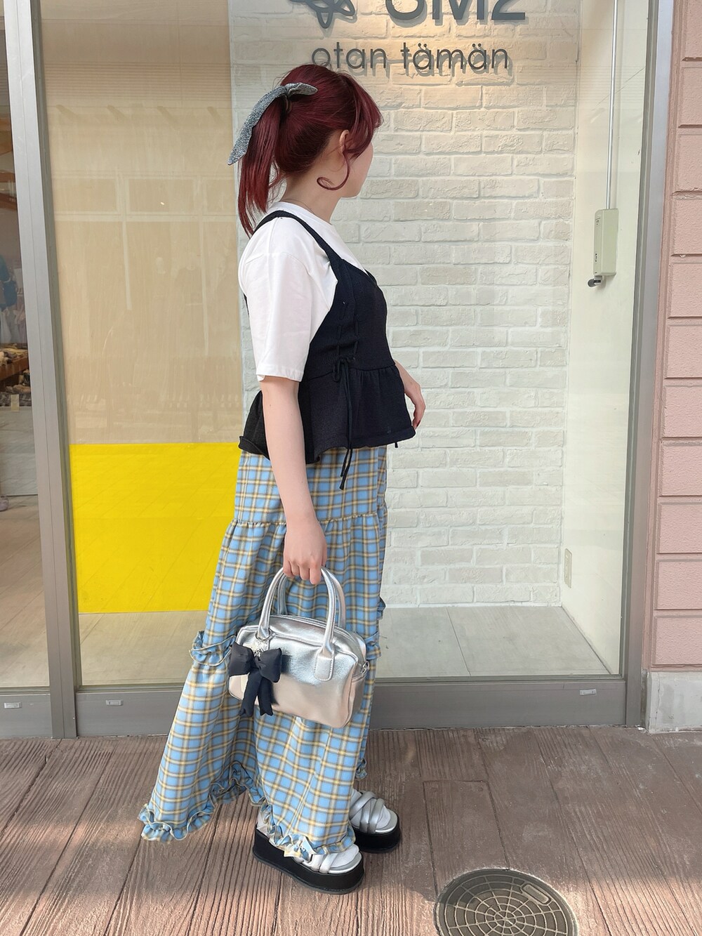 ホワイト系のTシャツ/カットソー、ブラック系のベスト、ブルー系のスカートを着用したレディースの春コーディネートの2枚目の写真