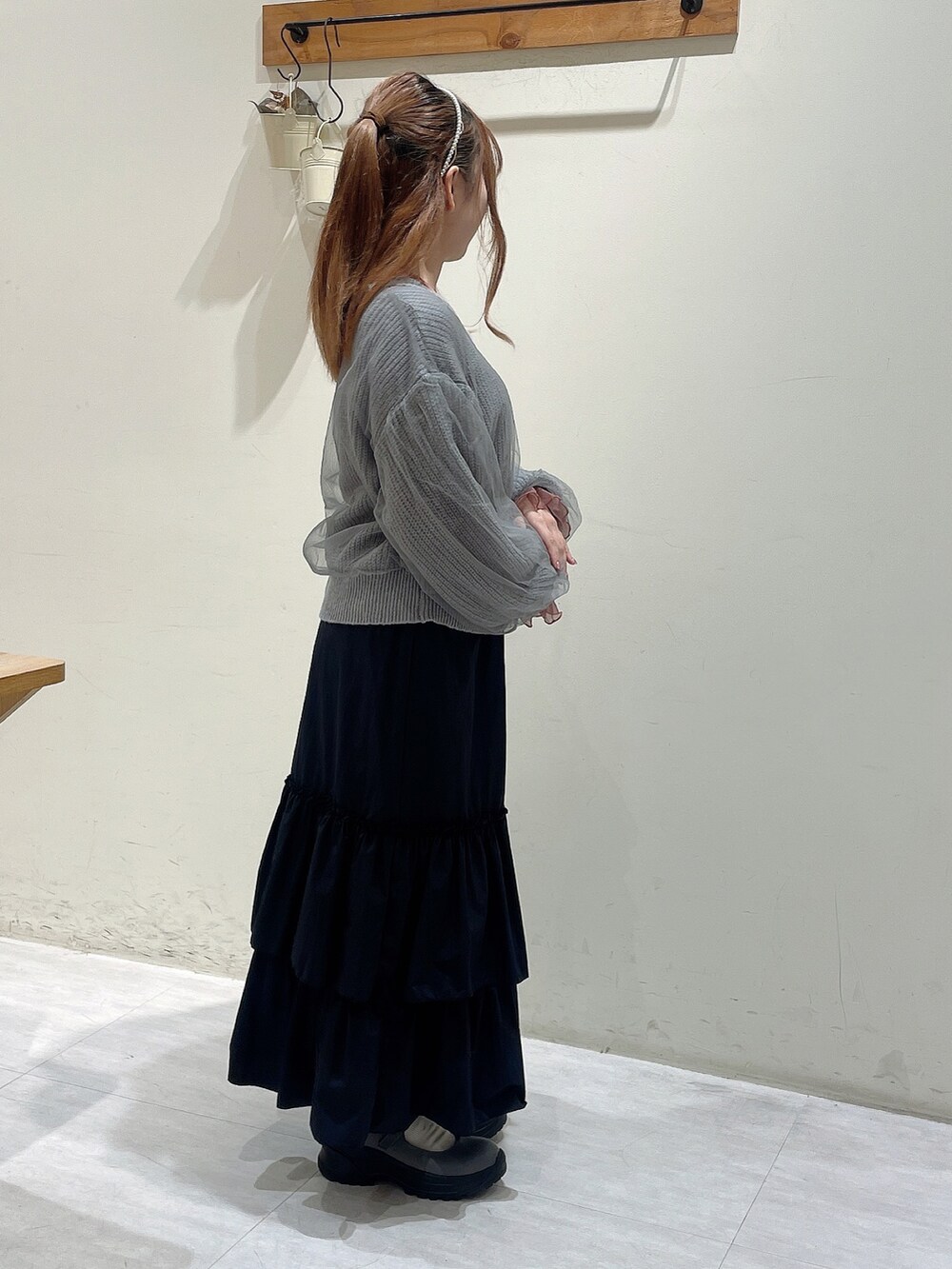 グレー系のカーディガン/ボレロ、ピンク系のTシャツ/カットソー、ブラック系のスカートを着用したレディースの秋コーディネートの2枚目の写真