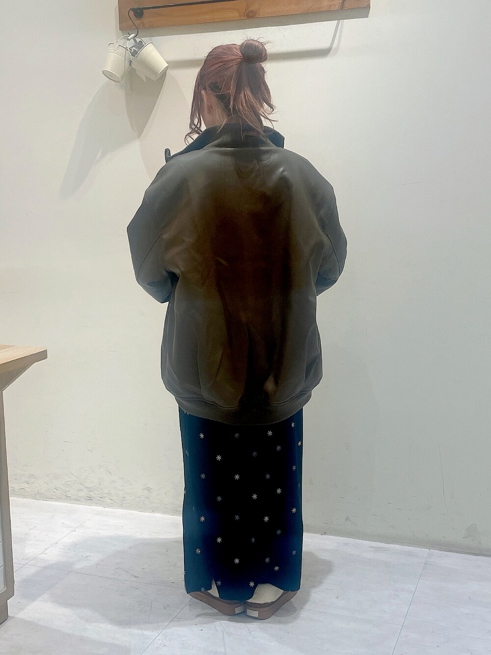 ブラウン系のジャケット/アウター、グレー系のTシャツ/カットソー、ブラック系のスカートを着用したレディースの冬コーディネートの4枚目の写真