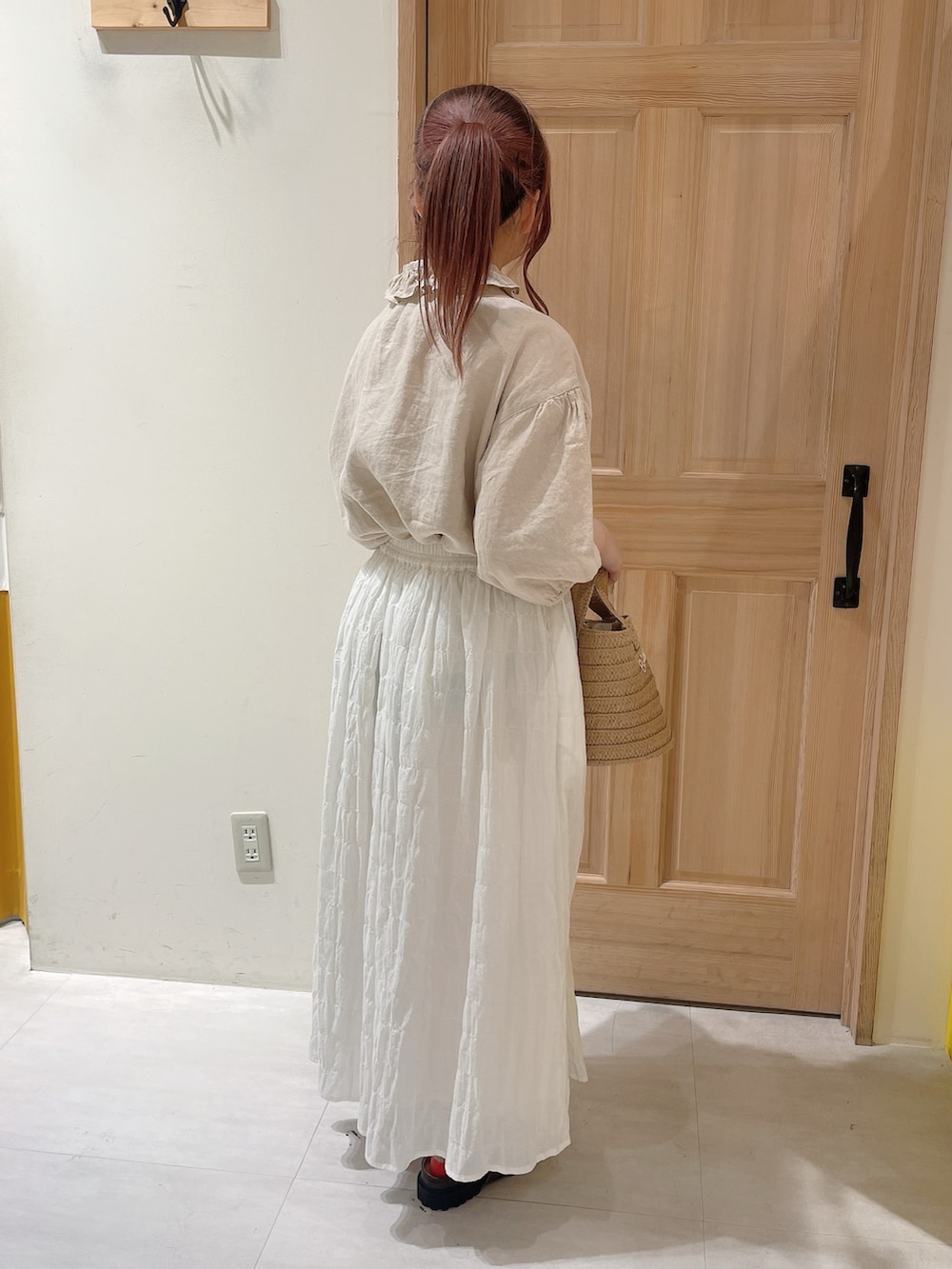 ベージュ系のシャツ/ブラウス、ホワイト系のスカート、ホワイト系のハンドバッグを着用したレディースの春コーディネートの2枚目の写真