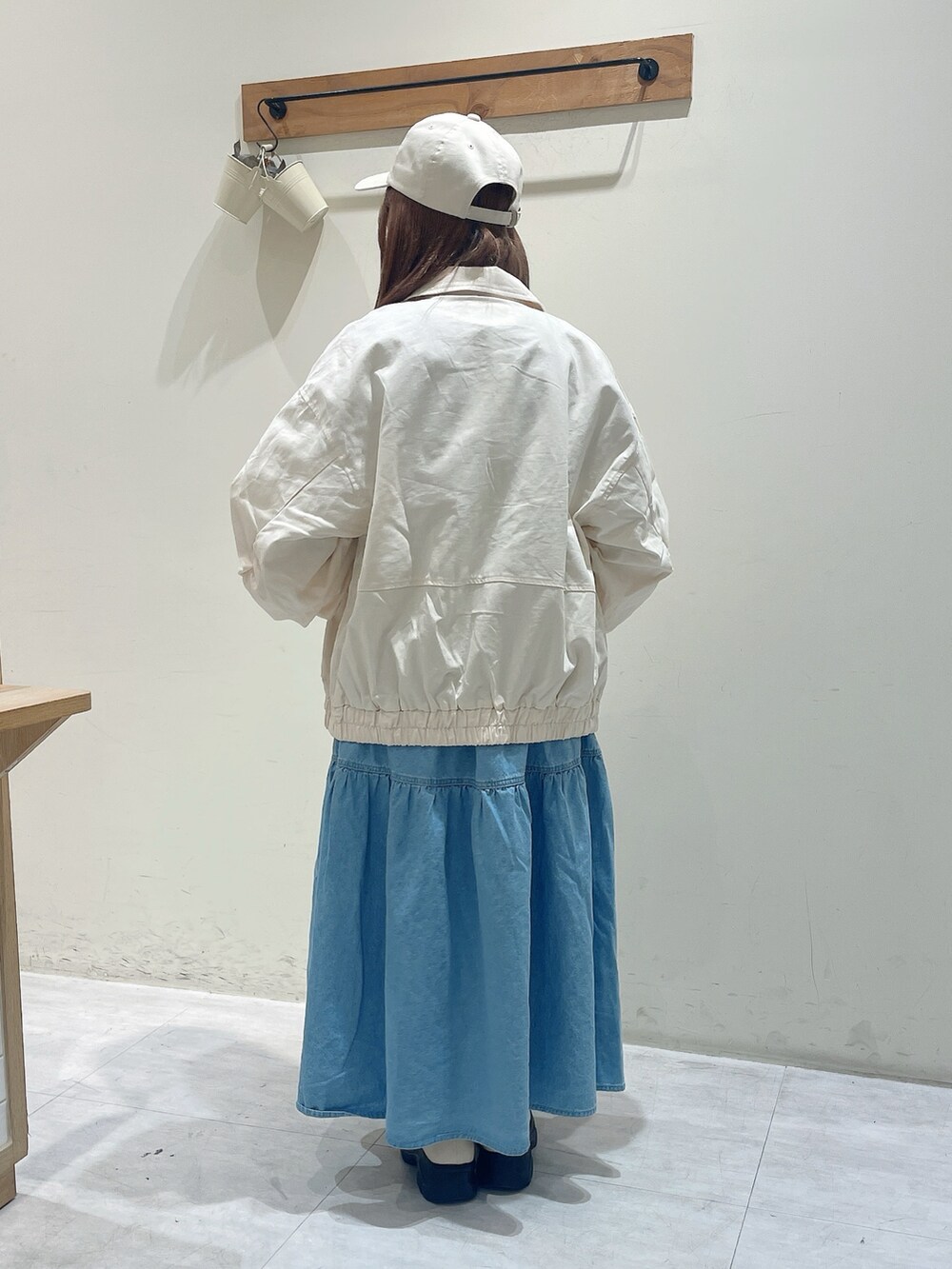 ホワイト系のブルゾン、ホワイト系のTシャツ/カットソー、ブルー系のワンピースを着用したレディースの春コーディネートの3枚目の写真