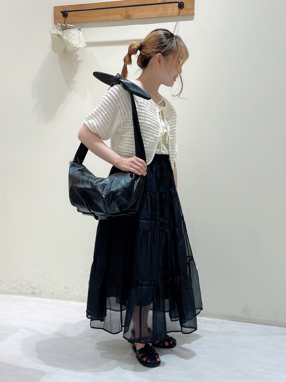 ホワイト系のカーディガン/ボレロ、ホワイト系のタンクトップ、ブラック系のハンドバッグを着用したレディースの夏コーディネートの2枚目の写真