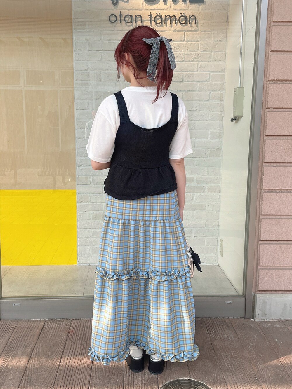 ホワイト系のTシャツ/カットソー、ブラック系のベスト、ブルー系のスカートを着用したレディースの春コーディネートの3枚目の写真