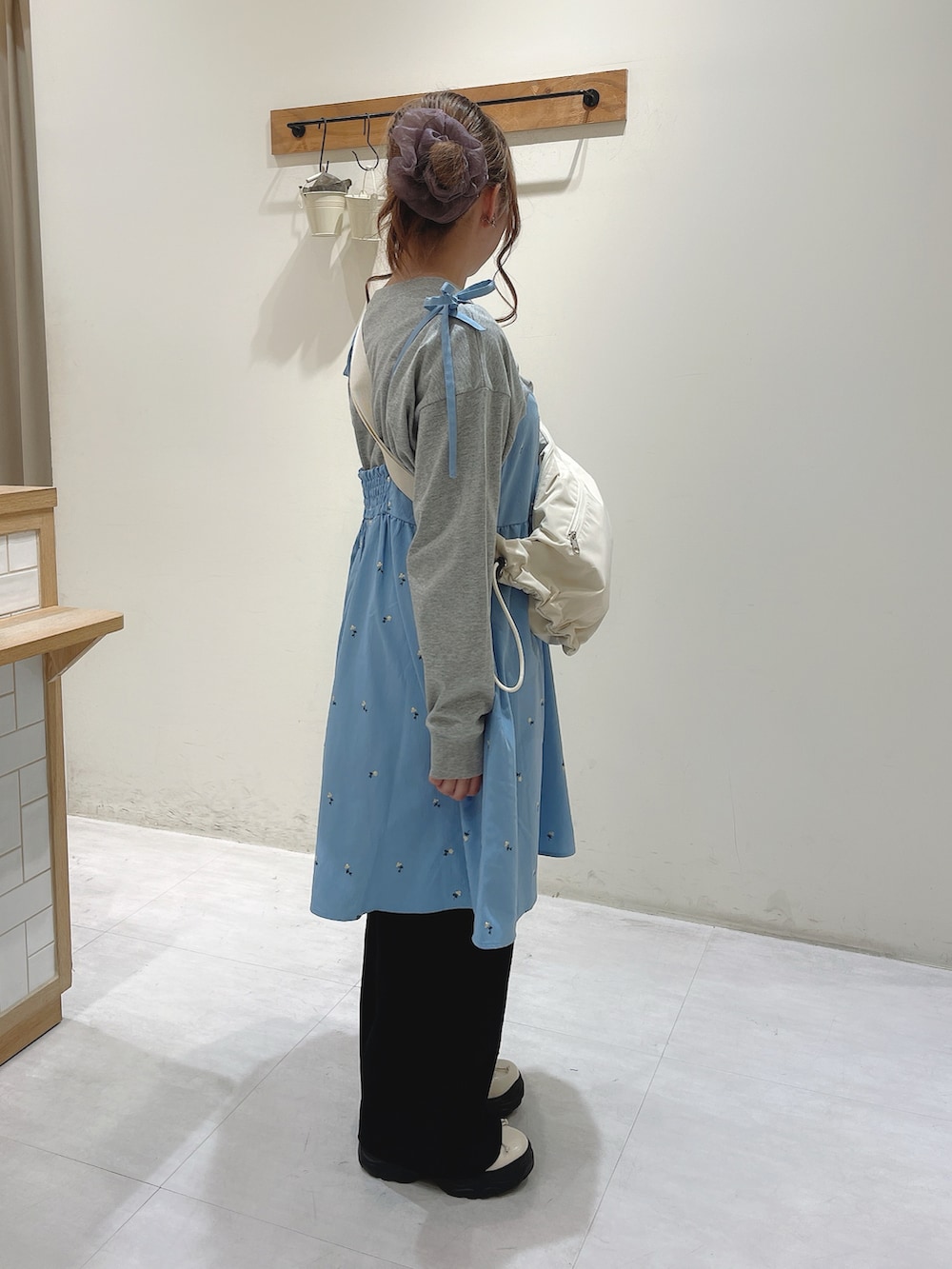 グレー系のTシャツ/カットソー、ブルー系のワンピース、ホワイト系のハンドバッグを着用したレディースの春コーディネートの2枚目の写真