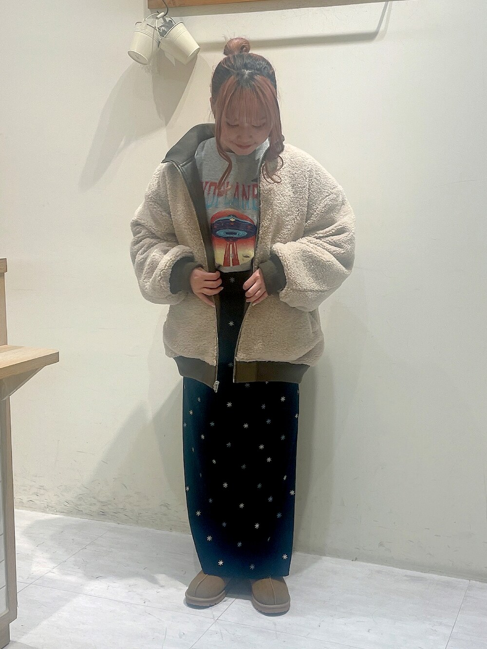 ブラウン系のジャケット/アウター、グレー系のTシャツ/カットソー、ブラック系のスカートを着用したレディースの冬コーディネートの2枚目の写真