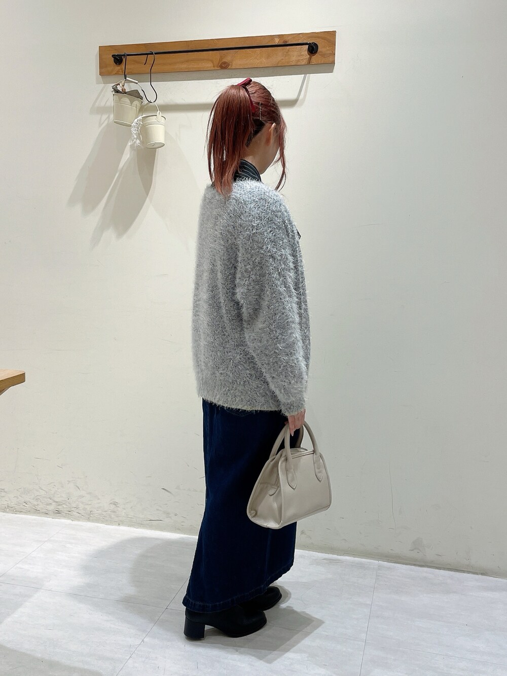 ブラック系のシャツ/ブラウス、ホワイト系のカーディガン/ボレロ、ベージュ系のハンドバッグを着用したレディースの秋コーディネートの2枚目の写真