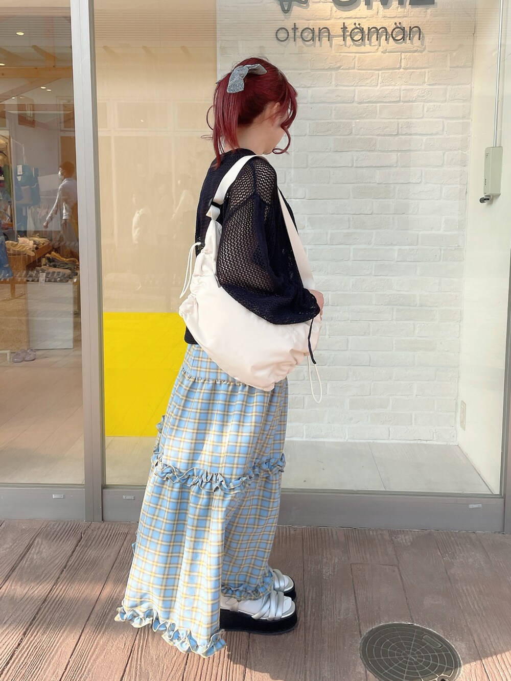 ブラック系のニット/セーター、ブラック系のタンクトップ、ブルー系のスカートを着用したレディースの春コーディネートの2枚目の写真