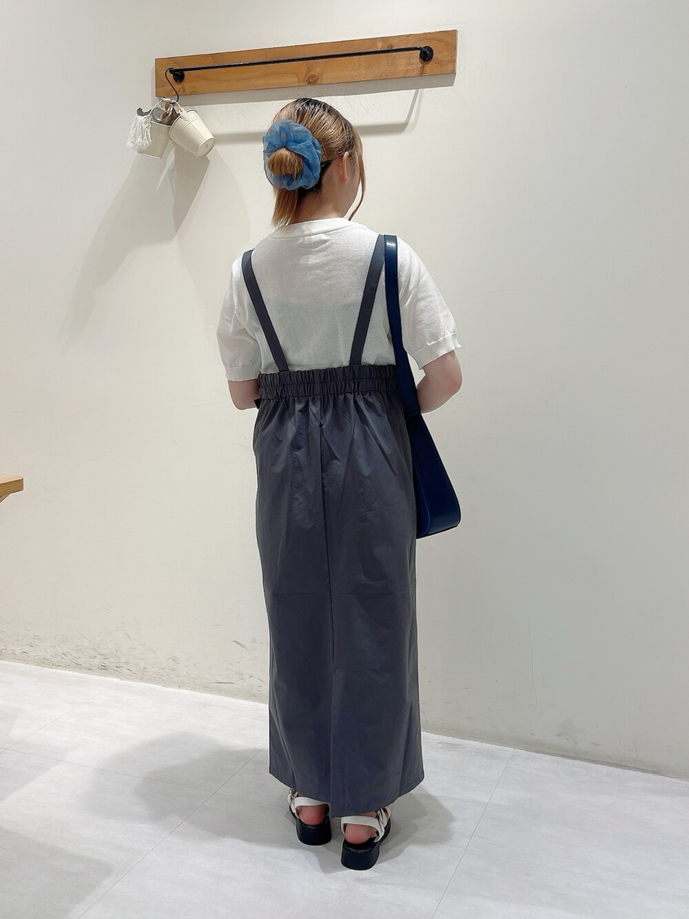 ホワイト系のニット/セーター、グレー系のスカート、ブルー系のハンドバッグを着用したレディースの夏コーディネートの3枚目の写真