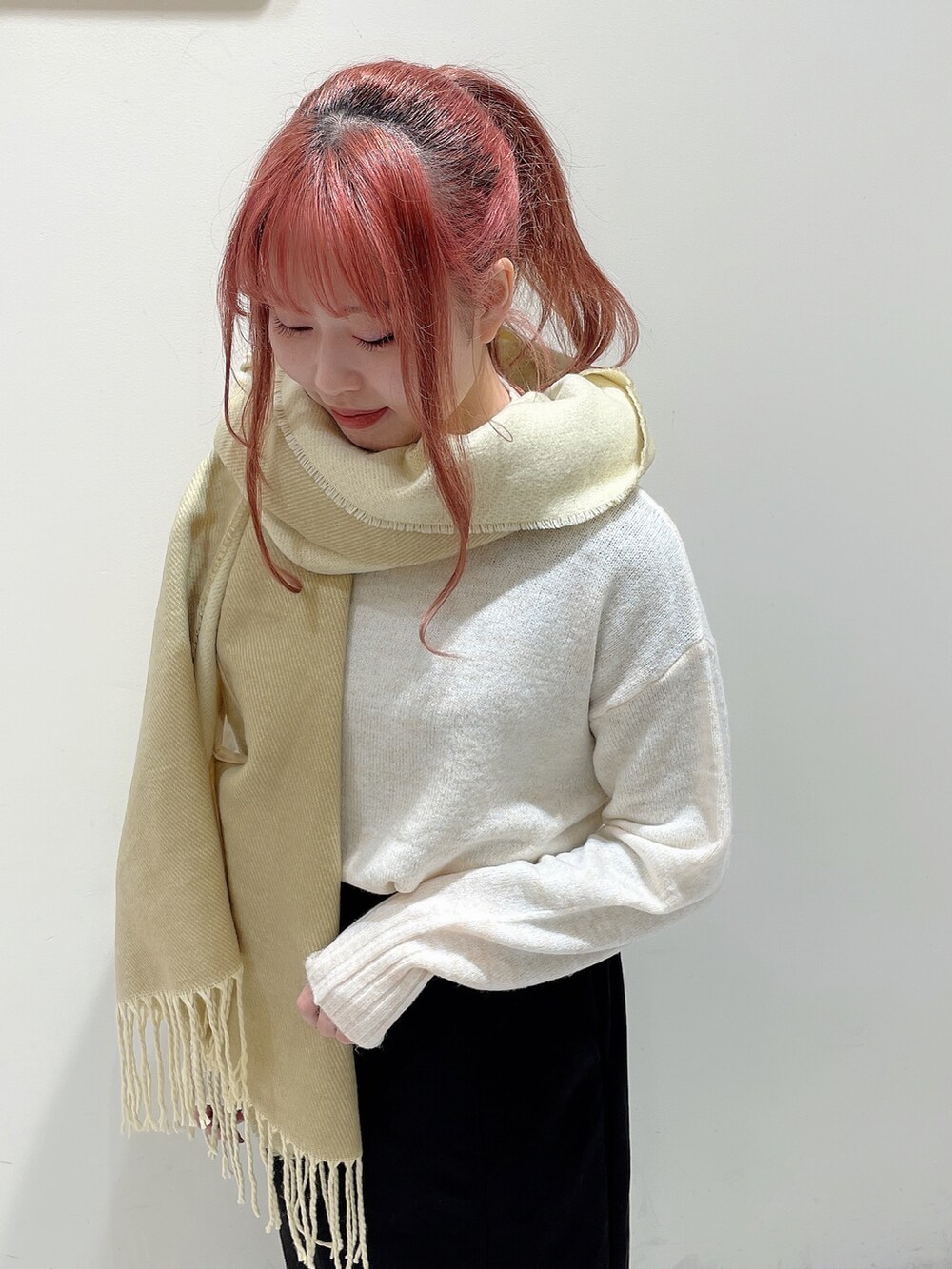 ホワイト系のニット/セーター、ブラック系のスカート、イエロー系のストール/ショールを着用したレディースの秋コーディネートの4枚目の写真