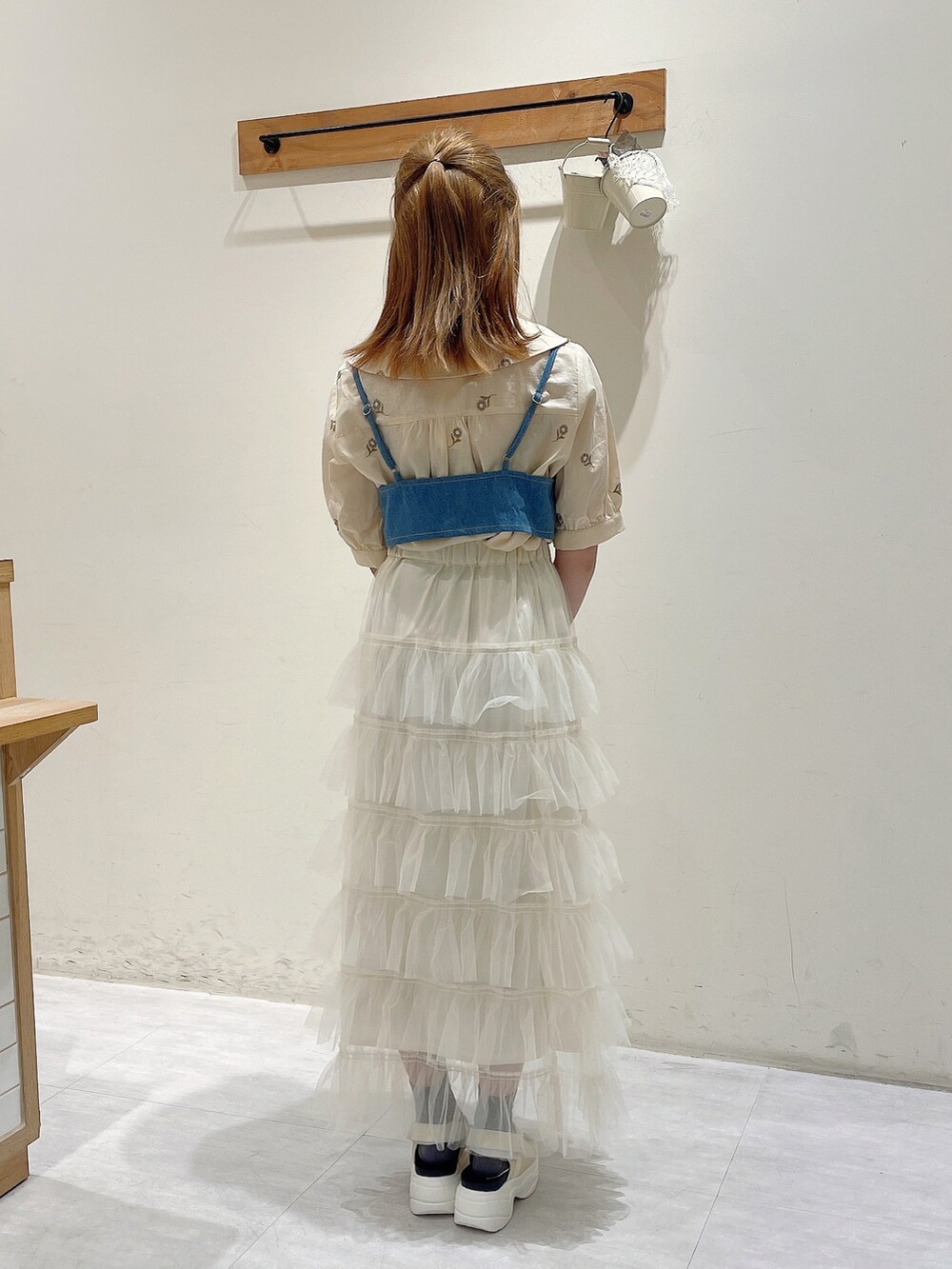 ホワイト系のシャツ/ブラウス、グリーン系のワンピース、ホワイト系のスカートを着用したレディースの春コーディネートの3枚目の写真