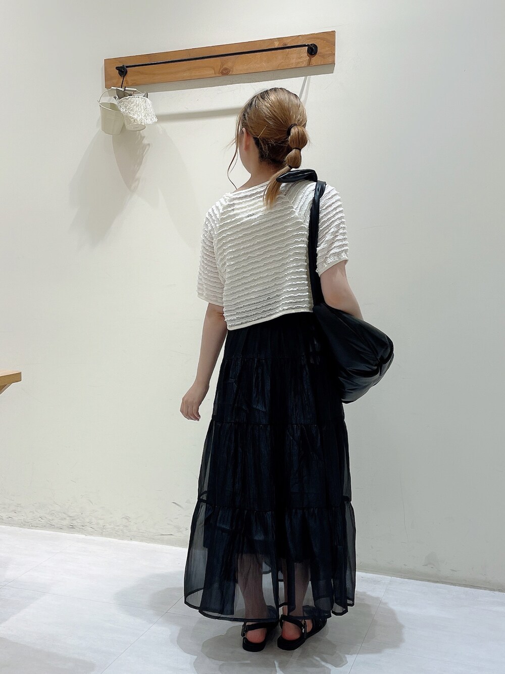 ホワイト系のカーディガン/ボレロ、ホワイト系のタンクトップ、ブラック系のハンドバッグを着用したレディースの夏コーディネートの3枚目の写真