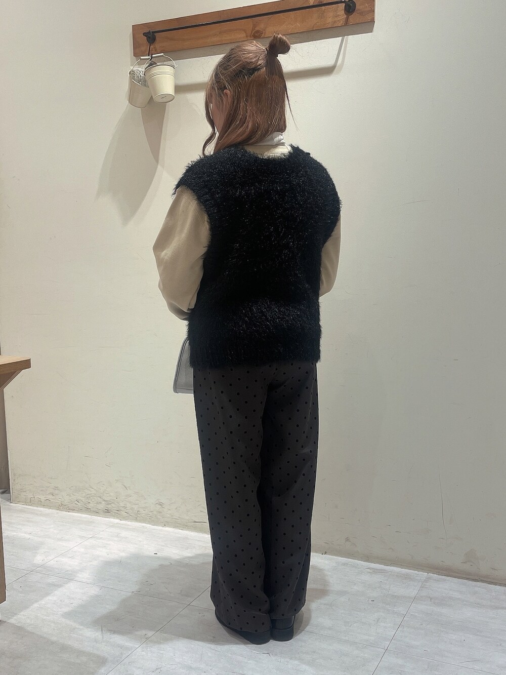 イエロー系のTシャツ/カットソー、ホワイト系のTシャツ/カットソー、ブラック系のニット/セーターを着用したレディースの冬コーディネートの3枚目の写真