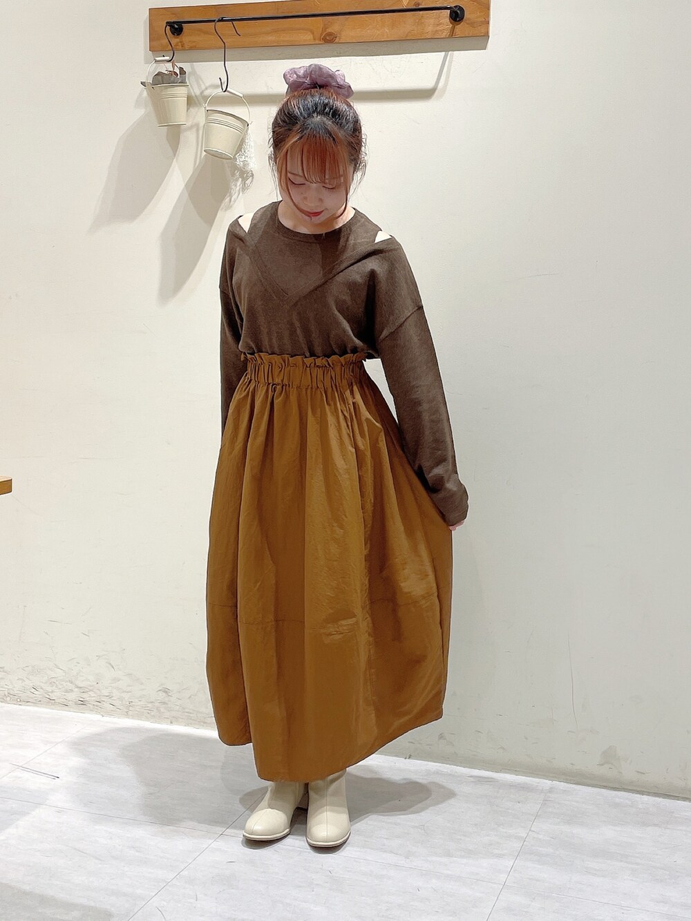 ブラウン系のニット/セーター、ホワイト系のノーカラージャケット、イエロー系のスカートを着用したレディースの秋コーディネートの2枚目の写真