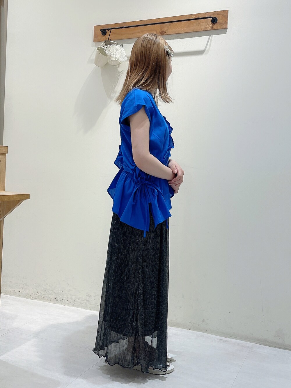 ブルー系のTシャツ/カットソー、ブラック系のスカート、シルバー系のドレスシューズを着用したレディースの夏コーディネートの2枚目の写真