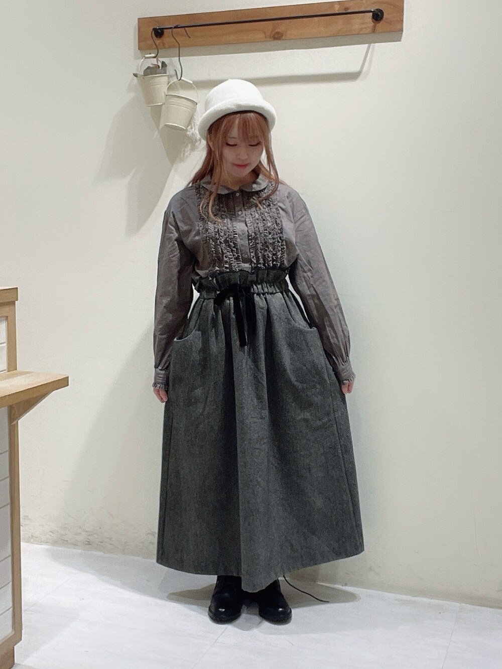 ブラック系のスカート、ブラック系のブーツ、ブラウン系のシャツ/ブラウスを着用したレディースの秋コーディネートの2枚目の写真