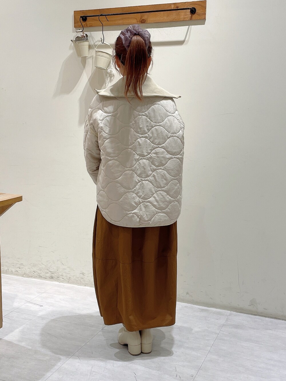 ブラウン系のニット/セーター、ホワイト系のノーカラージャケット、イエロー系のスカートを着用したレディースの秋コーディネートの4枚目の写真