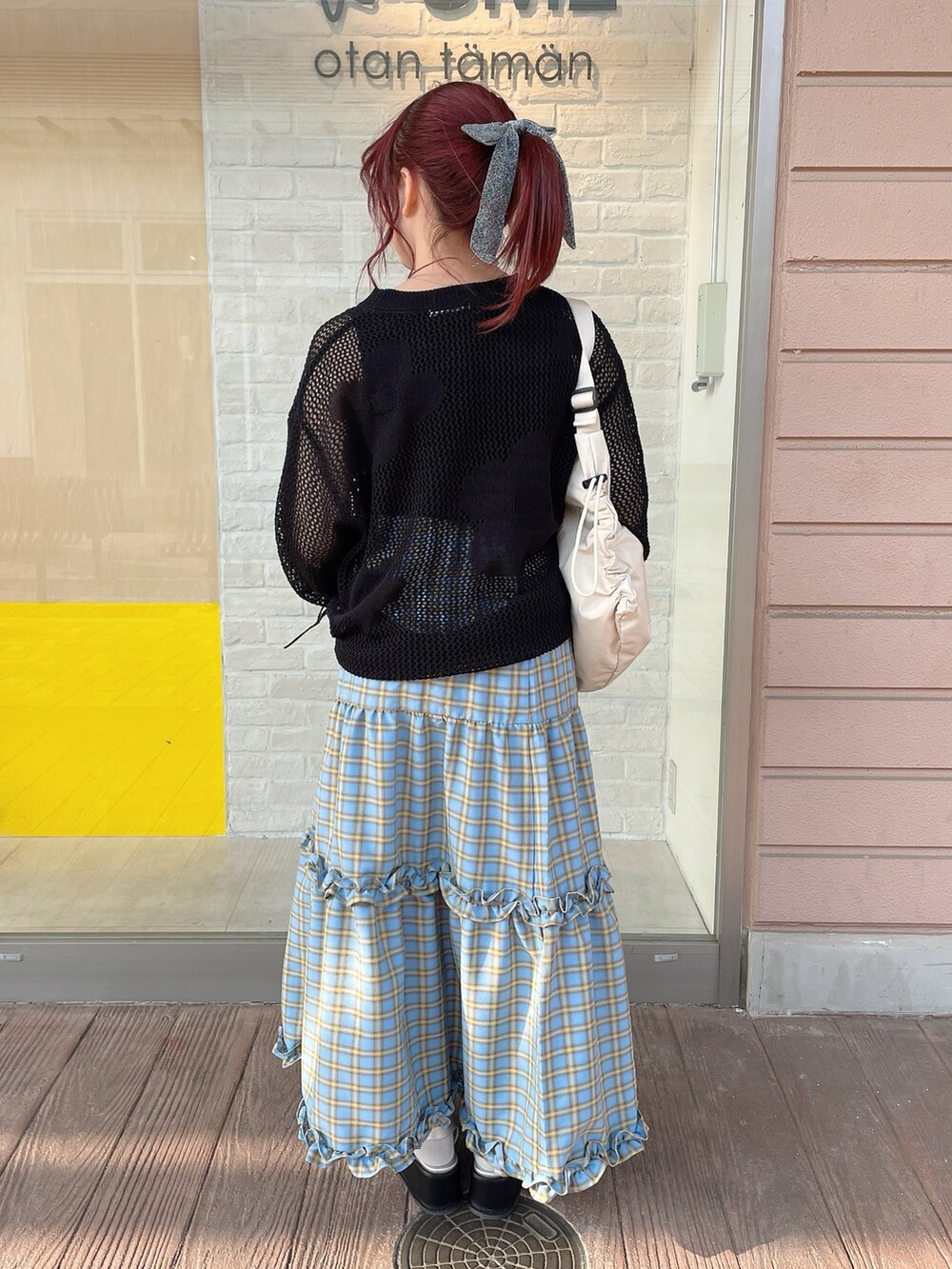 ブラック系のニット/セーター、ブラック系のタンクトップ、ブルー系のスカートを着用したレディースの春コーディネートの3枚目の写真