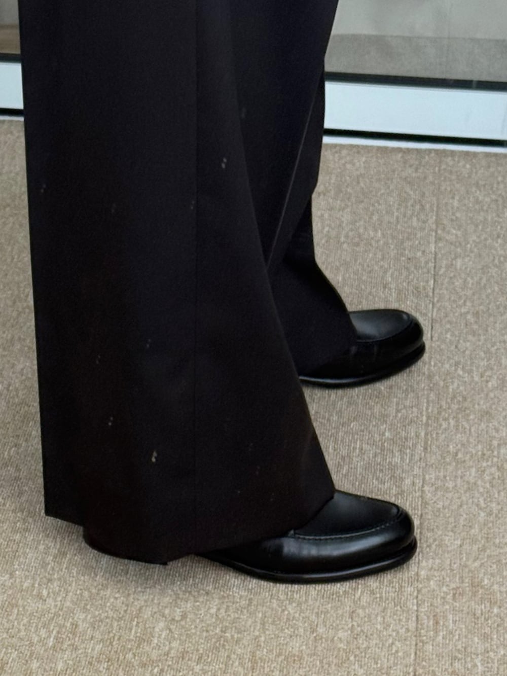 ブラック系のスラックス、ブラック系のドレスシューズ、ブラック系のトートバッグを着用したメンズの春コーディネートの5枚目の写真