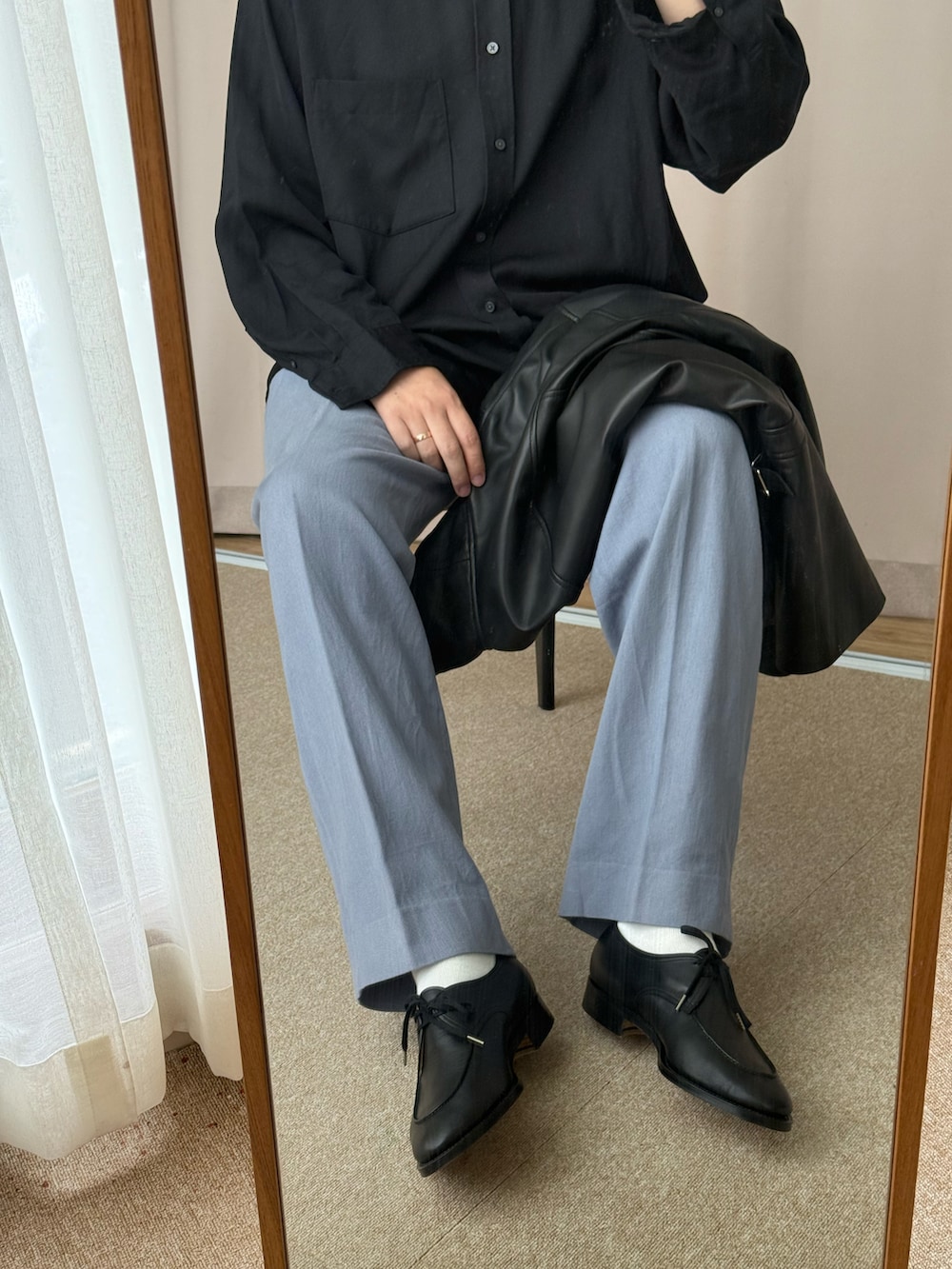 ブラック系のムートンコート、ブラック系のシャツ/ブラウス、ブルー系のチノパンツを着用したメンズの春コーディネートの3枚目の写真