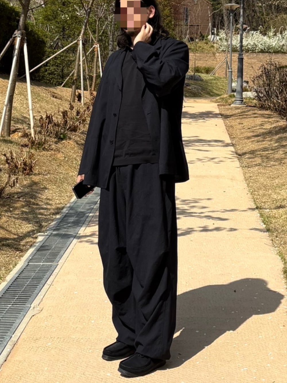 ブラック系のテーラードジャケット、ブラック系のスラックス、ブルー系のその他シューズを着用したメンズの春コーディネートの2枚目の写真