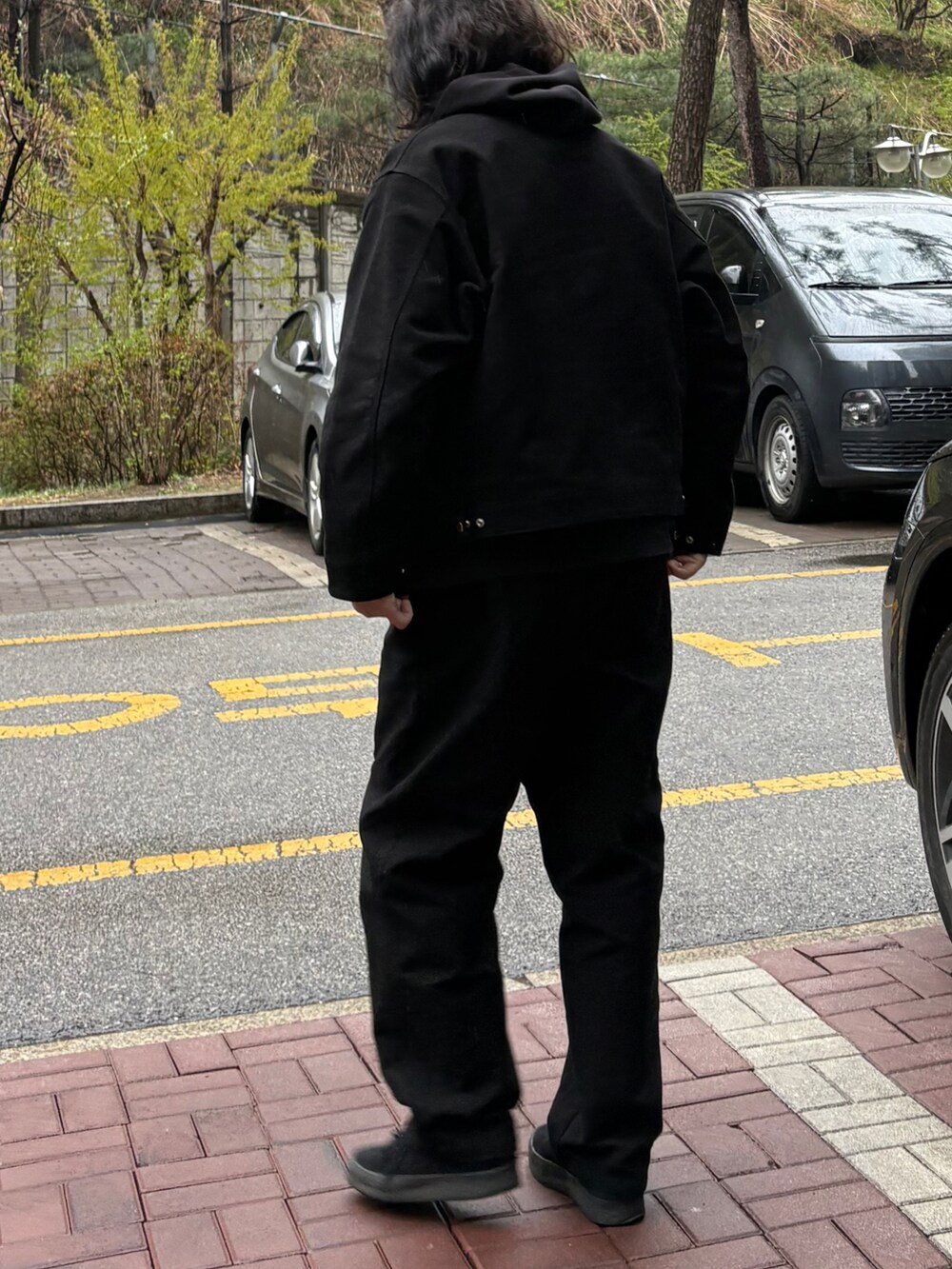 ブラック系のチノパンツ、ブラック系のブルゾン、ブラック系のスニーカーを着用したメンズの春コーディネートの3枚目の写真