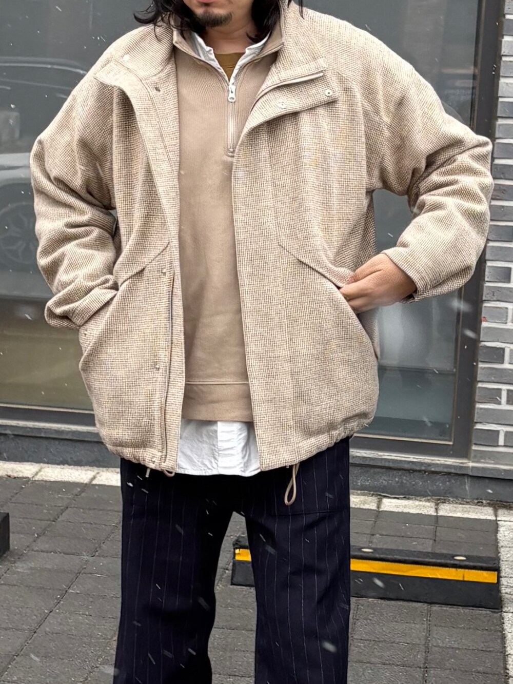 ブルー系のスラックス、ベージュ系のブルゾン、ブラック系のドレスシューズを着用したメンズの春コーディネートの4枚目の写真