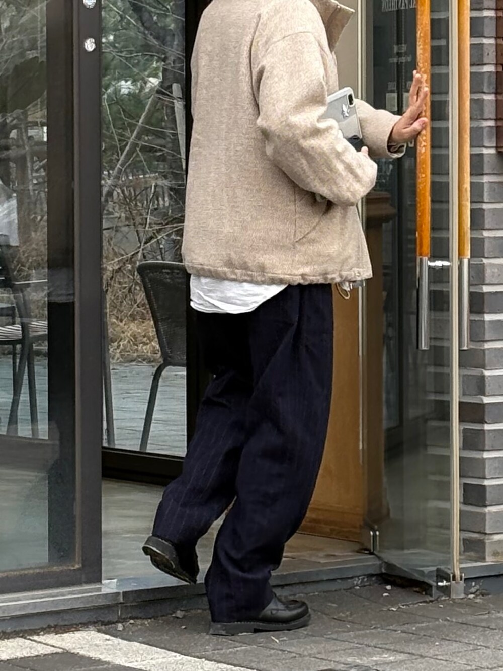 ブルー系のスラックス、ベージュ系のブルゾン、ブラック系のドレスシューズを着用したメンズの春コーディネートの3枚目の写真