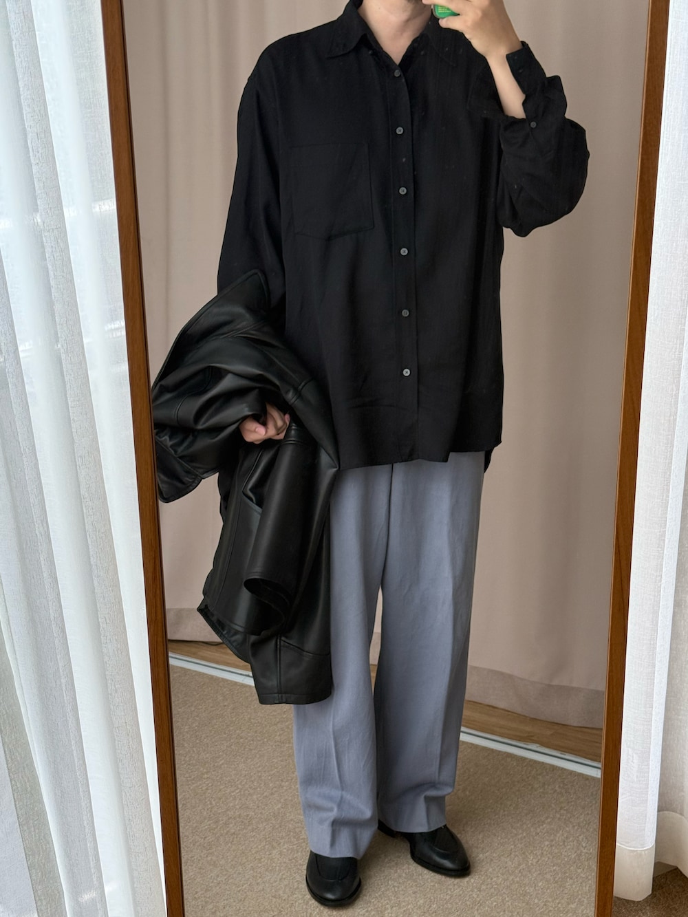 ブラック系のムートンコート、ブラック系のシャツ/ブラウス、ブルー系のチノパンツを着用したメンズの春コーディネートの2枚目の写真