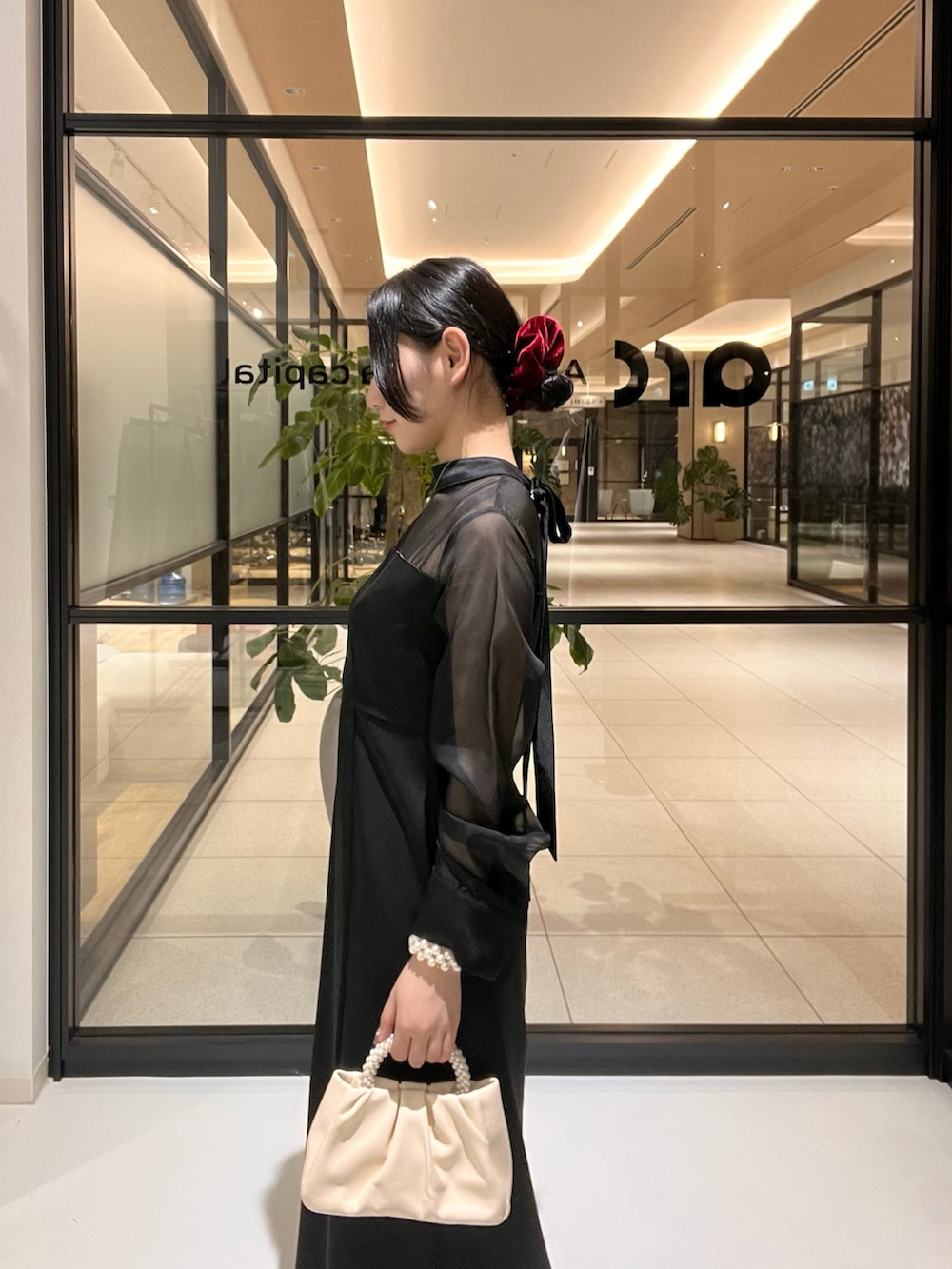 ブラック系のワンピースを着用したレディースの春コーディネートの2枚目の写真